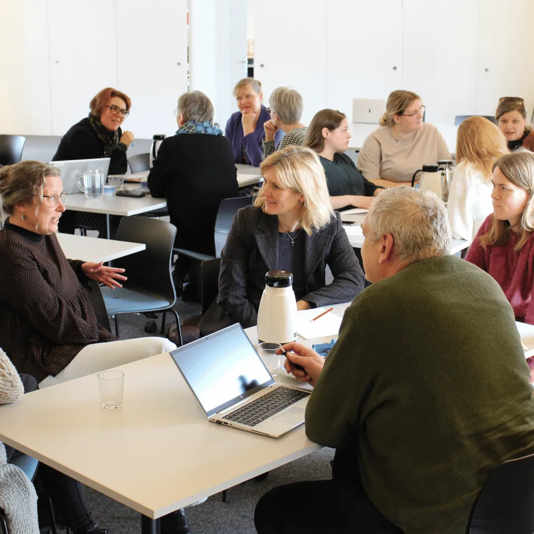 Mitarbeitende einer Kirchengemeinde arbeiten gemeinsam an einem Tisch